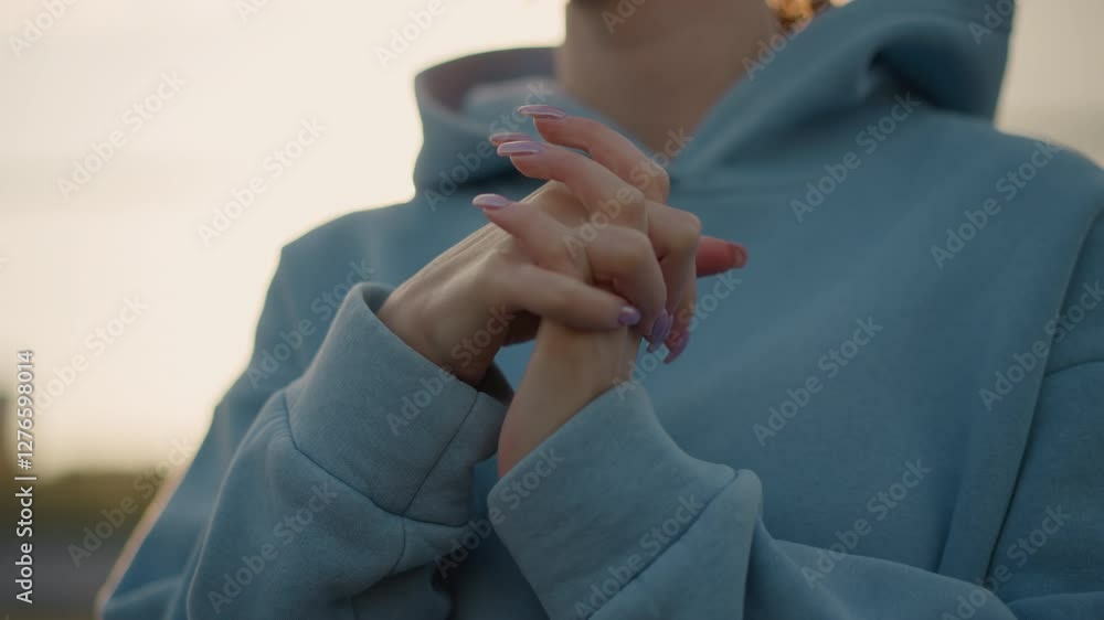 Close-up of lady with polished nails performing wrist twist, wearing blue sweater, showing hands in focus with soft background, elegant hands and wrist movement in fitness routine Close-up of lady with polished nails performing wrist twist, wearing blue sweater, showing hands in focus with soft background, elegant hands and wrist movement in fitness routine