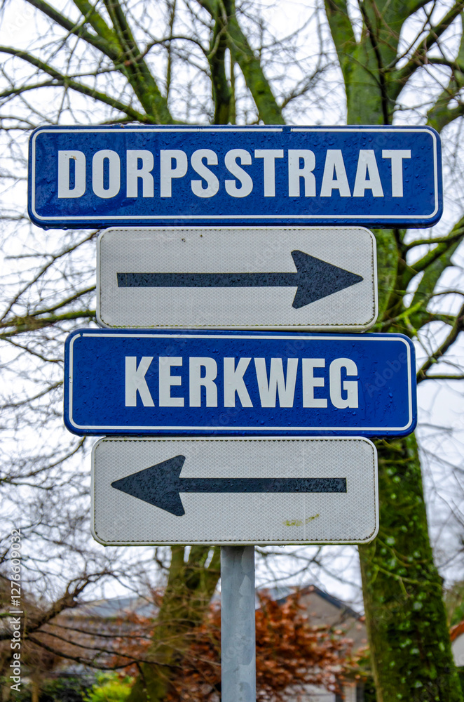 Fototapeta premium Schiedam, The Netherlands, January 25, 2025: two streetsigns with maybe the most common streetnames in the country, Dorpsstraat (Village Street) and Kerkweg (Church Road)