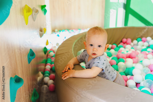 A boy playing in a children's ball pit with plastic balls