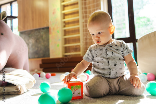 A little boy playing with blocks in a children's playroom