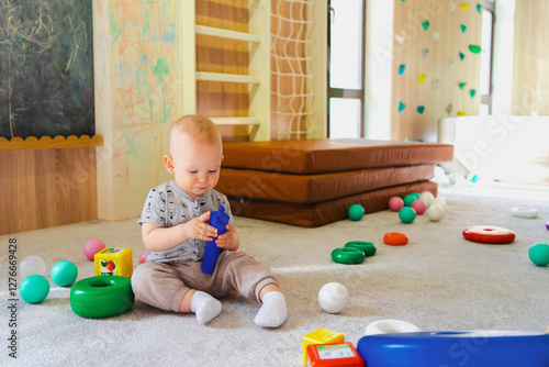A little boy playing alone in a playroom