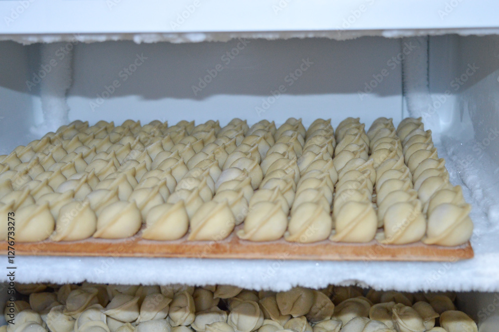 Fototapeta premium homemade dumplings pelmeni freezer storage shelves are filled with raw dumplings traditional food preparation process frozen food industry cooking culinary eastern european cuisine family life recipes
