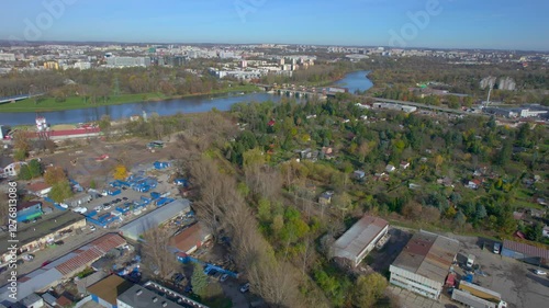 An aerial view of Kraków’s Zabłocie district, showcasing its dynamic transformation along the banks of the Vistula River. Once an industrial area, Zabłocie has evolved into a modern, thriving neighbor