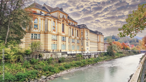 Fotografia Historic yellow building by the river in Feldkirch Austria surrounded by autumn