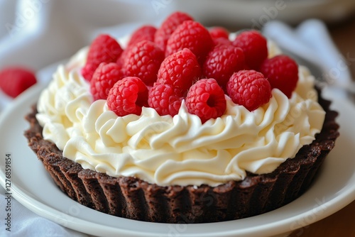 Delicious Chocolate Tart Topped With Fresh Raspberries and Whipped Cream on a...