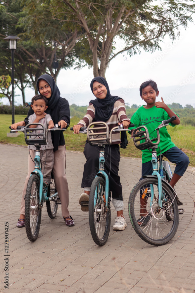 Fototapeta premium Happy Muslim Family Riding Bicycles in the Park Outdoors