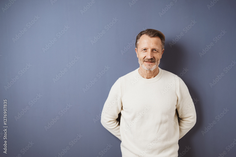 Smiling senior man in white sweater against blue background Smiling senior man in white sweater against blue background