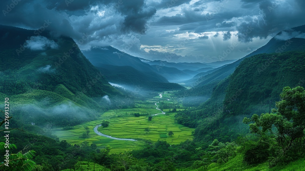 Obraz premium A vast verdant valley framed by towering misty mountains, where nature thrives under a dramatic sky.