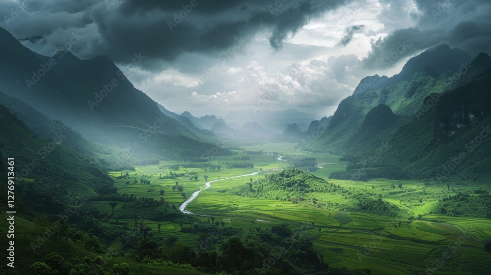 Obraz premium A vast verdant valley framed by towering misty mountains, where nature thrives under a dramatic sky.
