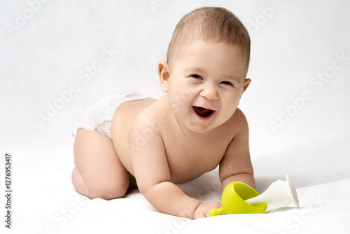 Happy 6 month old baby in photo studio holding rattle