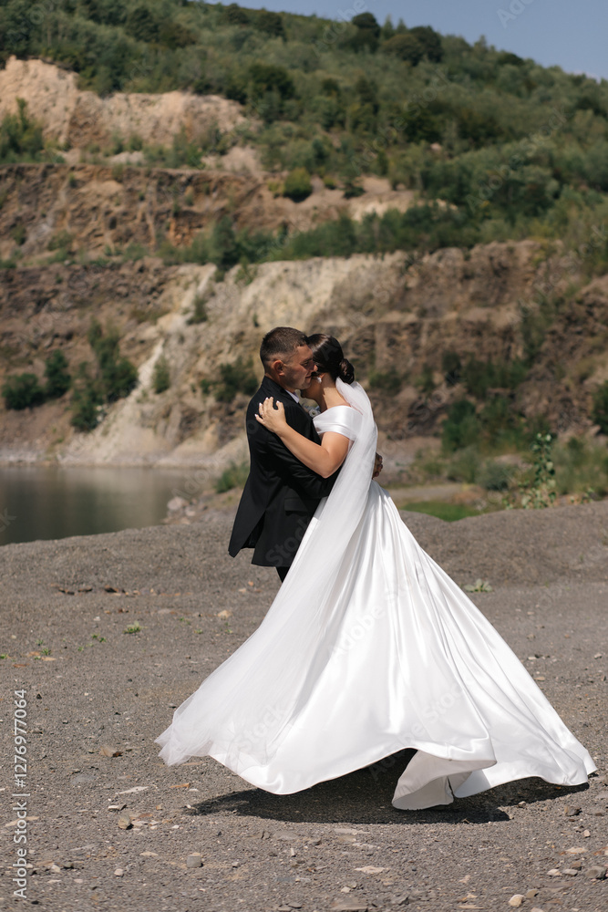 wedding, they are facing each other, touching their foreheads and hugging each other. In the background you can see a natural landscape with green trees and shrubs. wedding, they are facing each other, touching their foreheads and hugging each other. In the background you can see a natural landscape with green trees and shrubs.