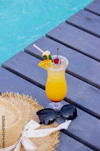 A nice cocktail, hat and sunglasses by the pool photo