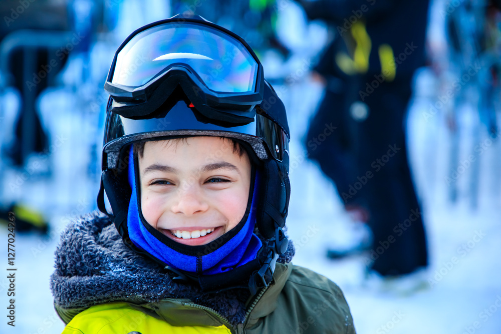 Portrait of little boy in ski equipment at ski resort