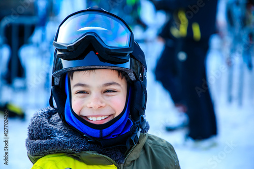 Portrait of little boy in ski equipment at ski resort