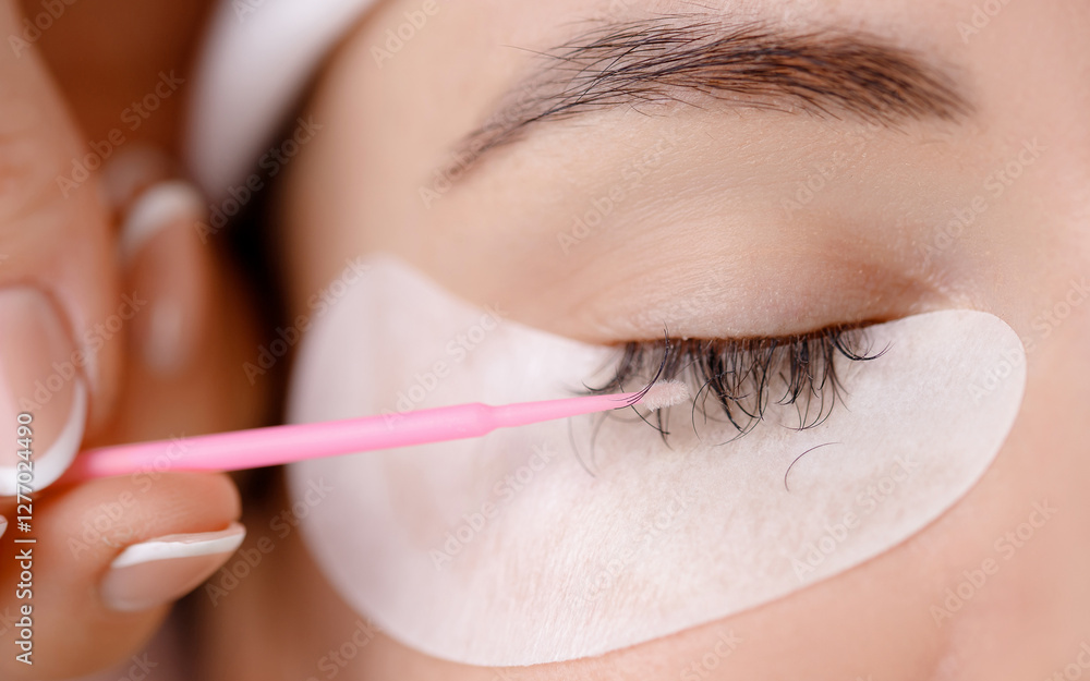 Obraz premium Closeup Eyelash extension removal procedure. Beautiful woman with long lashes in beauty salon
