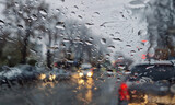 Melted snow and rain drops on the windshield of a car. Blurred outdoor view, winter season sleet as seen out of vehicle window.