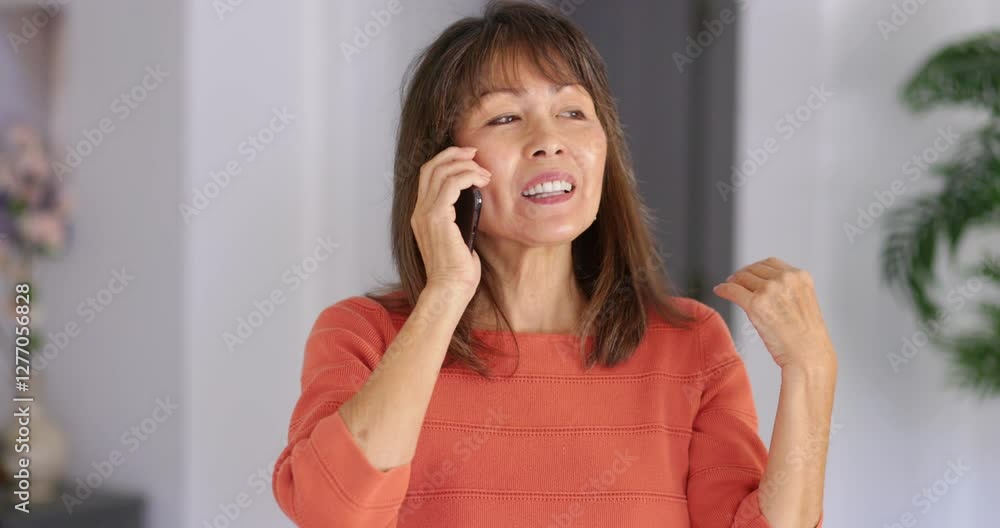 Woman smiling enjoying talking on cellphone standing at home head shot Woman smiling enjoying talking on cellphone standing at home head shot