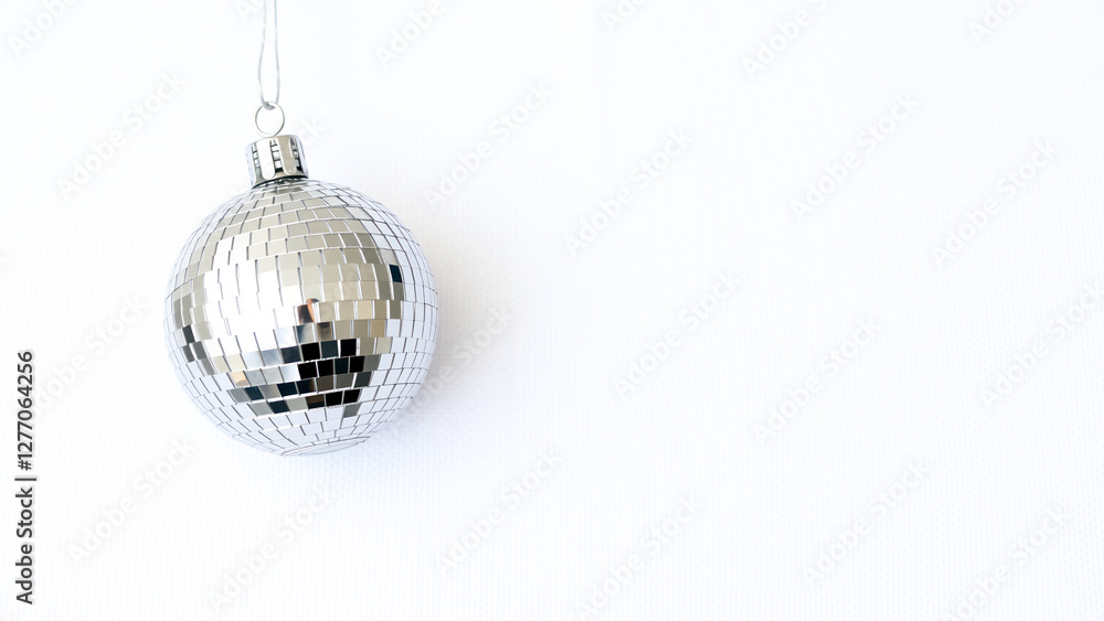Fototapeta premium silver disco ball ornament hanging against white background