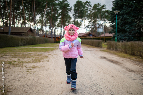 Little funny girl running in park outdoors