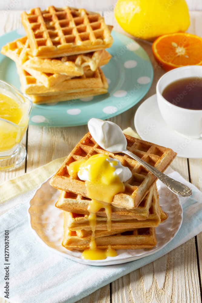 Belgian waffles with cream and lemon curd, served with tea.