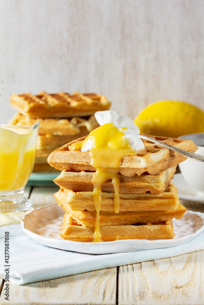 Belgian waffles with cream and lemon curd, served with tea.