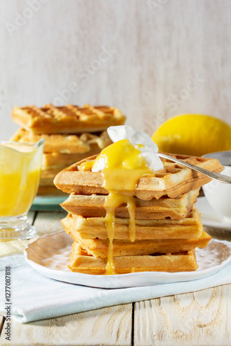 Belgian waffles with cream and lemon curd, served with tea.