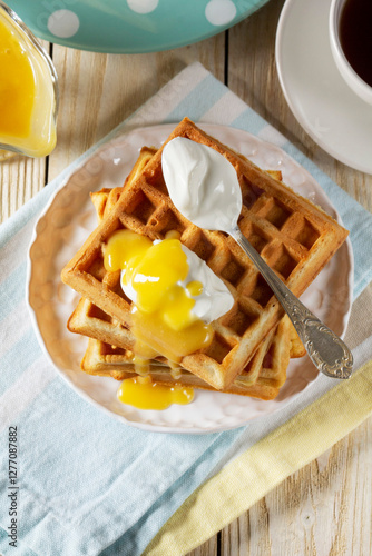 Obraz na płótnie Belgian waffles with cream and lemon curd, served with tea. w salonie