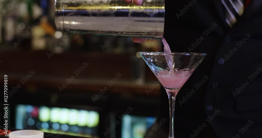 bartender pouring cocktail in bar