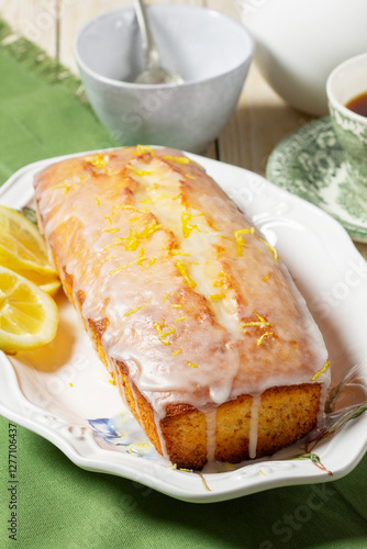 Obraz na płótnie Aromatic lemon cake, covered with sugar icing and sprinkled with zest, served with tea. w salonie
