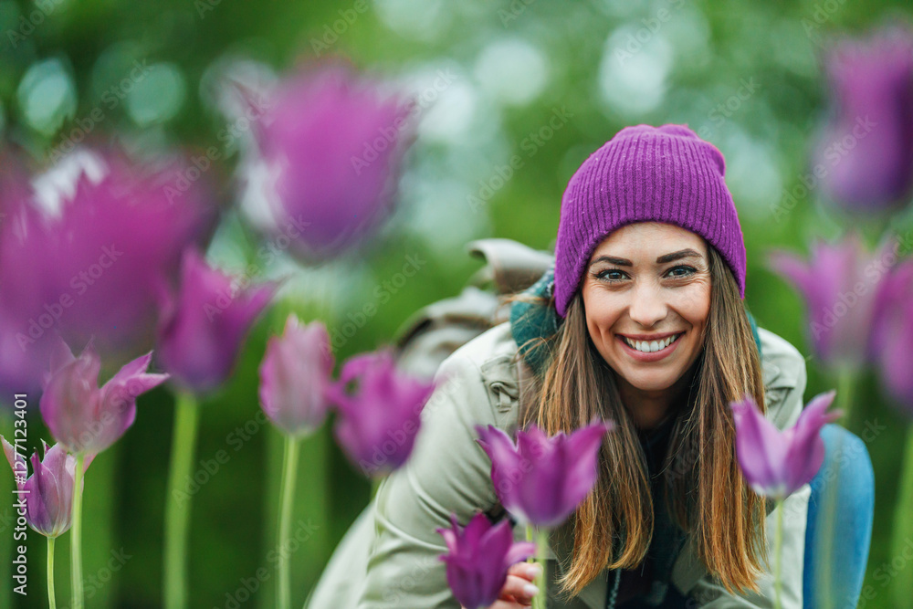 Smiling Woman Enjoying a Day in a Vibrant Flower Garden Smiling Woman Enjoying a Day in a Vibrant Flower Garden