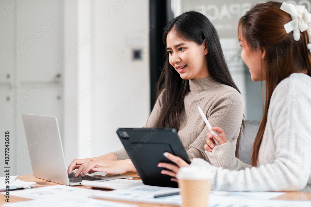 Two women working together in a modern office, using laptops and tablets, discussing ideas and collaborating on a project. Two women working together in a modern office, using laptops and tablets, discussing ideas and collaborating on a project.