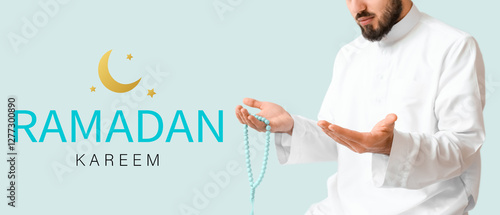 Praying young Muslim man on light background photo