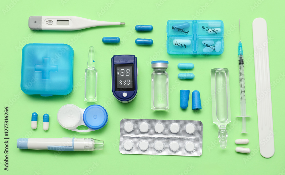 Composition with pulse oximeter, thermometer and different medicines on green background Composition with pulse oximeter, thermometer and different medicines on green background
