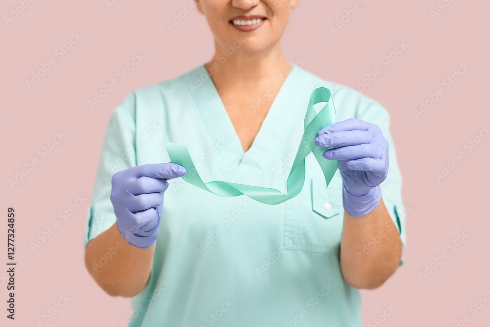 Mature female doctor with teal ribbon on pink background. Cervical Health Awareness Month Mature female doctor with teal ribbon on pink background. Cervical Health Awareness Month