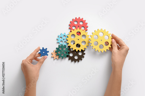 Hands holding wooden gears ...
