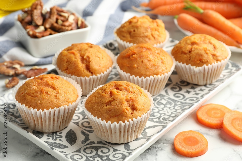 Tasty carrot muffins, fresh vegetables and walnuts on white marble table, closeup Tasty carrot muffins, fresh vegetables and walnuts on white marble table, closeup