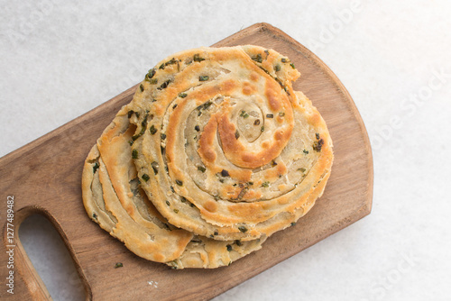 Overhead view of chinese scallion pancakes on a wood board, top view of golden-brown homemade scallion pancakes, process of making cong you bing photo