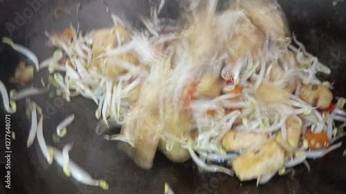 tofu and bean sprouts stir-fried with spices in a skillet