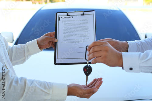 Bilde på lerret An asian male car salesman or sales manager offers to sell a car and explains an