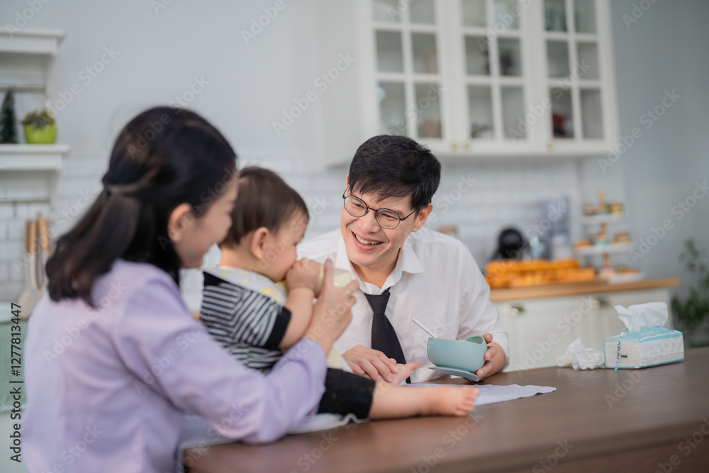 Happy family enjoys playful moments together in a cozy kitchen with a toddler and a caring adult Happy family enjoys playful moments together in a cozy kitchen with a toddler and a caring adult