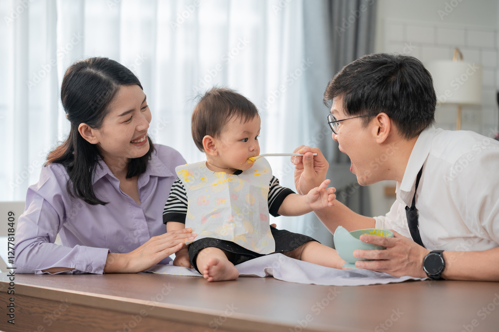 Parents feeding their toddler in a cozy kitchen during mealtime together Parents feeding their toddler in a cozy kitchen during mealtime together