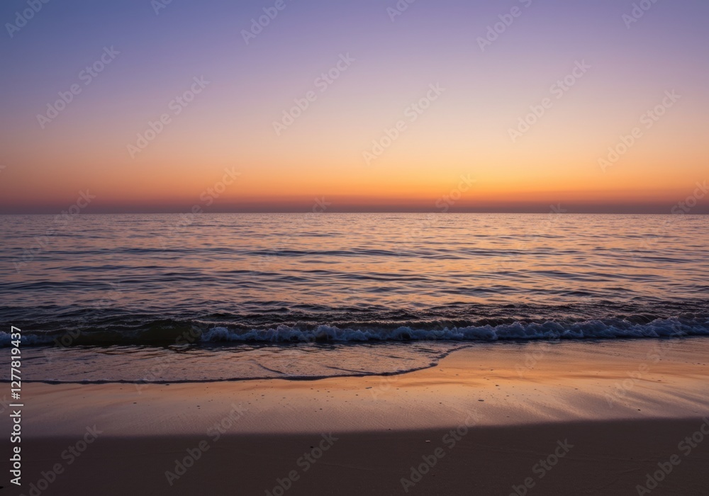 Fototapeta premium Tranquil beach at sunset with gentle waves and vibrant sky
