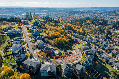 Aerial drone view of Happy Valley, Oregon, in autumn, showcasing vibrant fall foliage, residential neighborhoods, tree-lined streets, rolling hills, and suburban landscapes with golden and red leaves