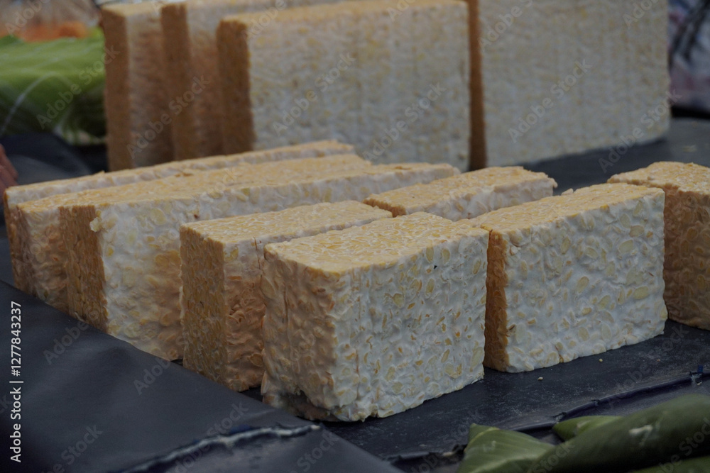 Raw Tempeh or Tempe in traditional market. Indonesian traditional food, made from fermented soybeans. Usually fried for a side dish or for other cooking ingredients. Raw Tempeh or Tempe in traditional market. Indonesian traditional food, made from fermented soybeans. Usually fried for a side dish or for other cooking ingredients.