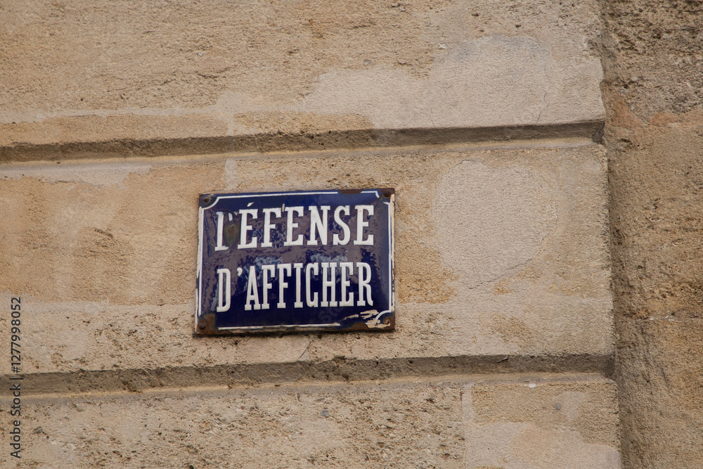 Fototapeta premium Prohibition to display on a wall defense d'afficher old vintage french text sign on building wall means Do not stick posters