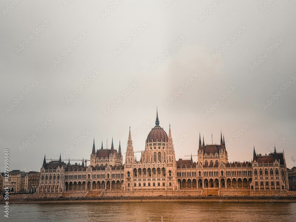 Fototapeta premium Hungarian Parliament Building on an Overcast Day A stunning view of the Hungarian Parliament Building in Budapest, Hungary, captured on a cloudy and moody day. The grand neo-Gothic architecture stands