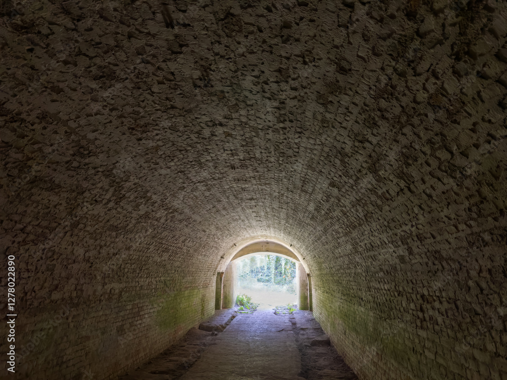 Fototapeta premium Tunnel lined with red bricks in the old fortress
