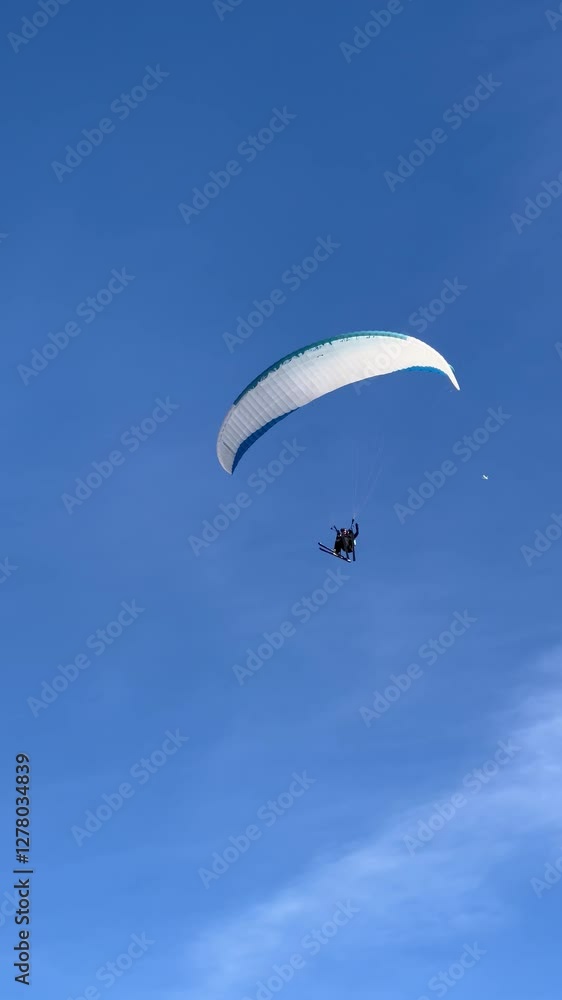 Skier Paraglider flying with ski over the hills of French alps Skier Paraglider flying with ski over the hills of French alps