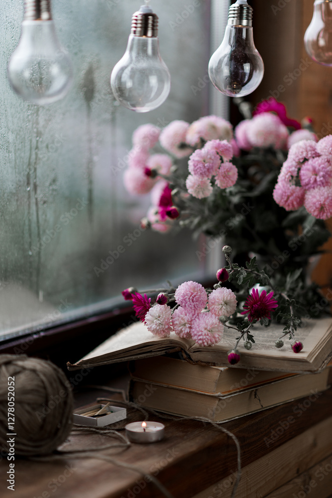 pink flowers in a glass vase on a wooden windowsill against a background of raindrops, books and flowers, garland pink flowers in a glass vase on a wooden windowsill against a background of raindrops, books and flowers, garland