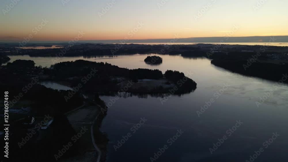 Aerial Drone Shot at Sunset with Silhouetted Forest Overlooking a Tranquil Lake Aerial Drone Shot at Sunset with Silhouetted Forest Overlooking a Tranquil Lake